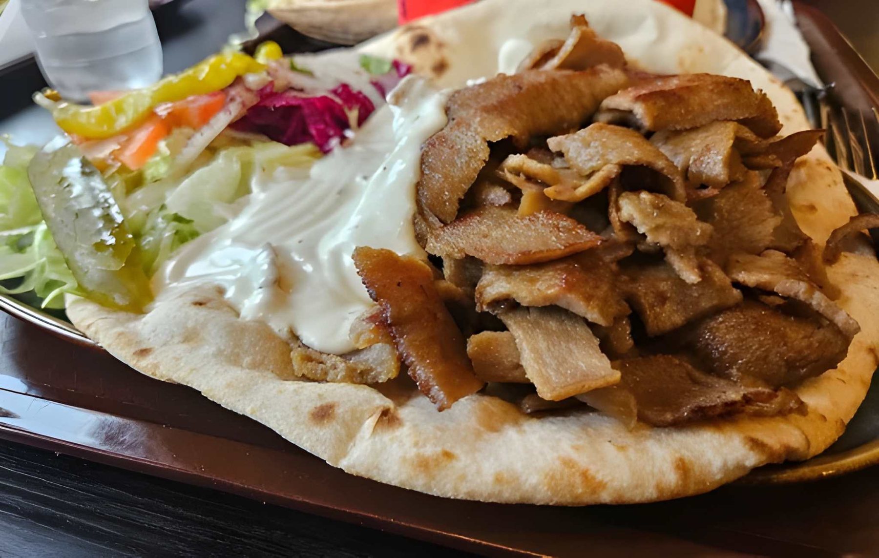 Doner kebab on warm flatbread with salad and garlic sauce